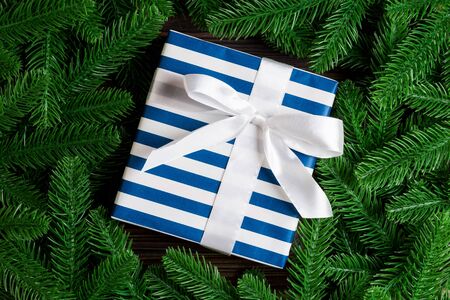 Top view of festive gift box decorated with green fir tree branches. Christmas time with copy space.の写真素材