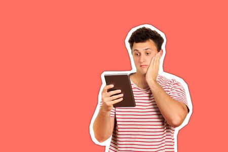 shocked guy looking at camera and holding a tablet computer. emotional guy isolated Magazine collage style with trendy color.の写真素材