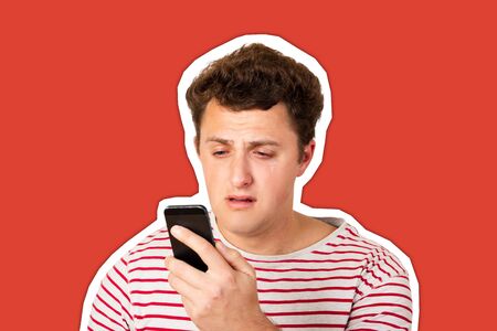 A crying man reads a text message on his phone. Sms with bad news. emotional man isolated Magazine...