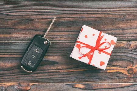 Valentine or other holiday handmade present in paper with red hearts, car keys and gifts box in holiday wrapper. box gift on Farkwooden table top view with copy space, empty space for design.の写真素材