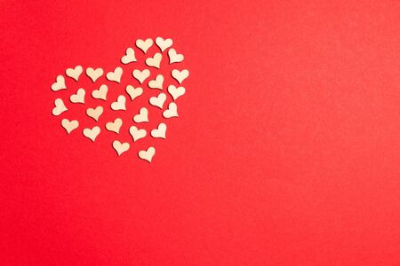 Top view of heart shape made of small wooden hearts on colorful background. Love concept....