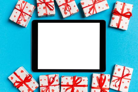 Top view of digital tablet surrounded with gift boxes on colorful background. Saint Valentine's day.の写真素材