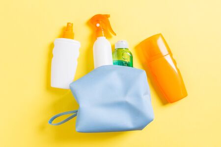 Top view of female cosmetics bag full of suncream spray, sunsreen, sunblock and body lotion and spf...
