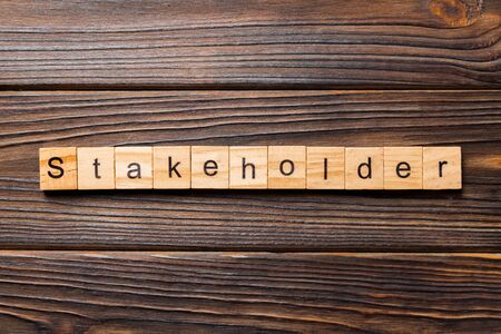 Stakeholder word written on wood block. Stakeholder text on wooden table for your desing, concept.