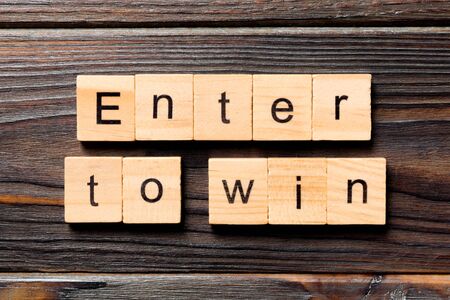 Enter To Win word written on wood block. Enter To Win text on wooden table for your desing, concept.の写真素材