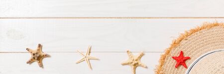 Straw hat and starfish On a white wooden background. top view summer holiday banner concept with copy space.の写真素材