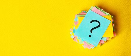 question marks written reminders tickets on yellow vintage paper background.の写真素材
