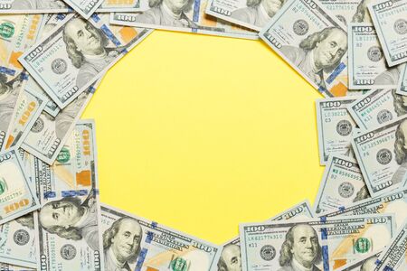 Frame of one hundred dollar bills with empty space for your design. Top view of business concept on yellow background with copy space.の写真素材