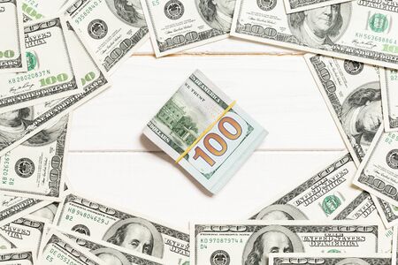 Frame of one hundred dollar bills with stack of money in the middle. Top view of business concept on...