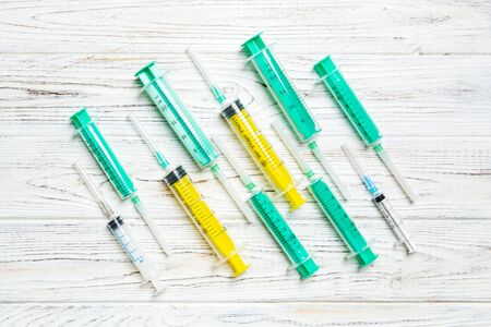 Top view of many syringes prepared for injection at wooden background. Treatment concept with copy space.の写真素材