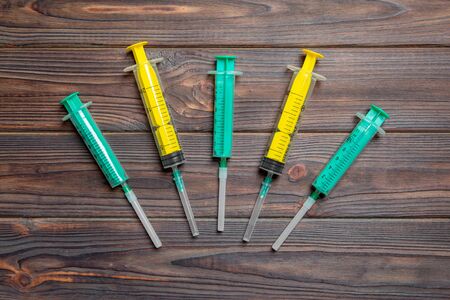 Top view of many syringes prepared for injection at wooden background. Treatment concept with copy space.の写真素材