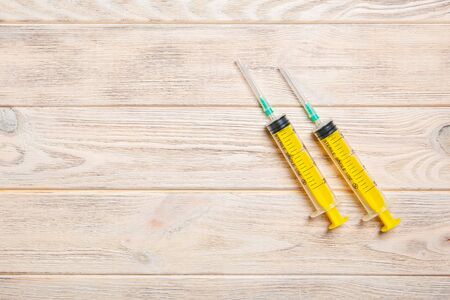 Top view of syringes on wooden background with copy space. Medical equipment for injection concept.の写真素材