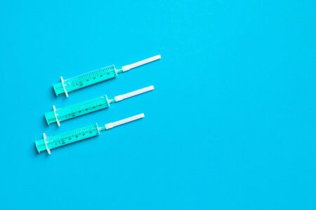 Top view of syringes in a row for medical injection on colorful background with copy space. Health...