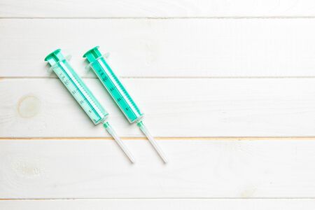 Top view of syringes on wooden background with copy space. Medical equipment for injection concept.