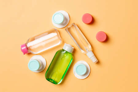 Top view composition of small traveling bottles and jars for cosmetic products on colored background. Facial skin care concept with copy space for your design.の写真素材