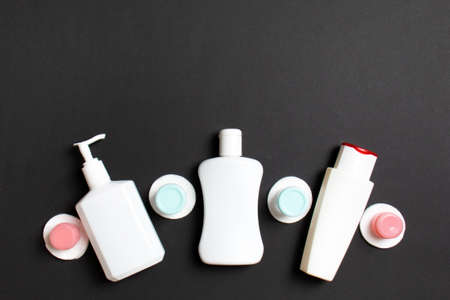 Set of travel size cosmetic bottles on colored background. Flat lay of cream jars. Top view of...