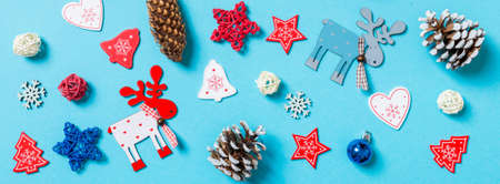 Top view of New Year toys and decorations on blue background. Banner Christmas time concept.