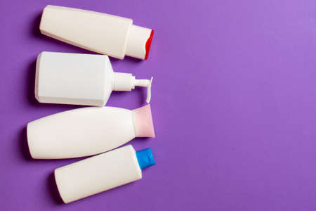 Set of White Cosmetic containers isolated on colored background, top view with copy space. Group of plastic bodycare bottle containers with empty space for you design.の写真素材