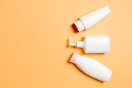 Set of White Cosmetic containers isolated on colored background, top view with copy space. Group of...