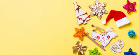 Top view Banner of Christmas decorations and Santa hats on yellow background. Happy holiday concept...