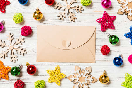 Top view of envelope on festive wooden background. Christmas toys and decorations. New Year time concept.の写真素材