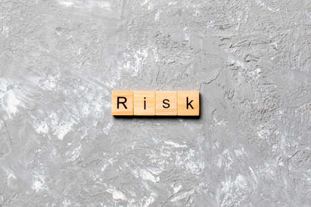 Risk word written on wood block. Risk text on cement table for your desing, concept.の写真素材