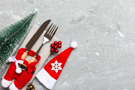 Top view of fork and knife tied up with ribbon on napkin on cement background. Christmas decorations and New Year tree. Happy holiday concept with empty space for your design.の写真素材