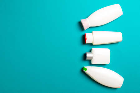 Set of White Cosmetic containers isolated on colored background, top view with copy space. Group of plastic bodycare bottle containers with empty space for you design.の写真素材