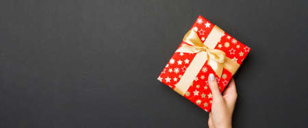 Top view of female hands holding christmas or other holiday handmade present box package in the...