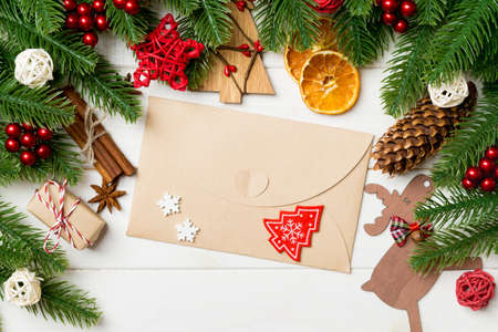 Top view of fir tree branches, envelope and festive decorative toys on wooden background. New Year time concept.の写真素材