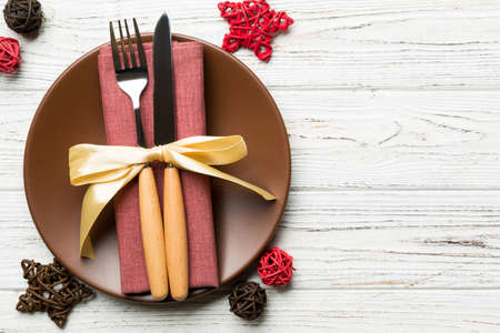 Holiday composition of Christmas dinner on wooden background. Top view of plate, utensil and festive decorations. New Year Advent concept with copy space.の写真素材