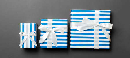 wrapped Christmas or other holiday handmade present in paper with White ribbon on black background....