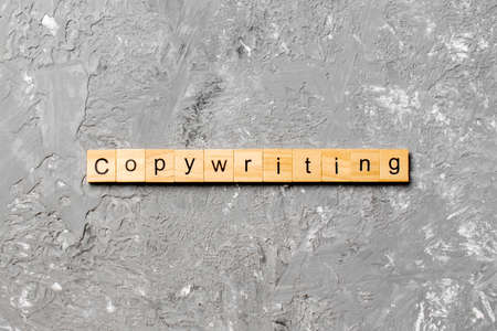 Copywriting word written on wood block. Copywriting text on cement table for your design, concept.の写真素材