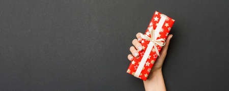 Top view of female hands holding christmas or other holiday handmade present box package in the...