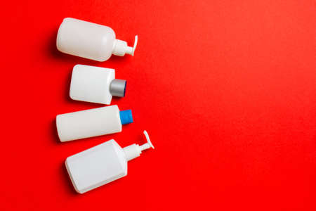 Set of White Cosmetic containers isolated on colored background, top view with copy space. Group of plastic bodycare bottle containers with empty space for you design.の写真素材