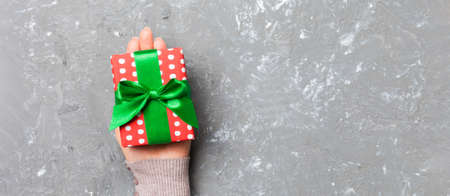 Top view of female hands holding christmas or other holiday handmade present box package in the...