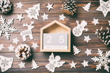 Top view of calendar on Christmas wooden background. The twenty fifth of December. New Year toys and...