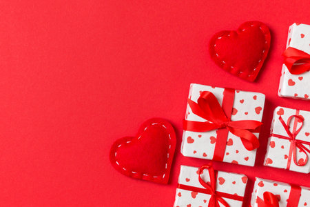 Holiday composition of gift boxes and red textile hearts on colorful background with empty space for your design. Top view of Valentine's Day concept.の写真素材