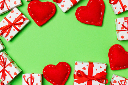 Top view of festive gift boxes and red textile hearts on colorful background with copy space. St Valentine's day concept.の写真素材