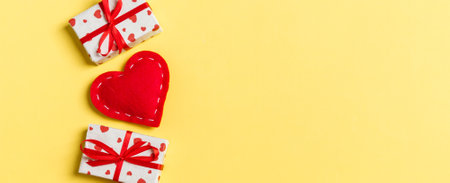 Holiday composition of gift boxes and red textile hearts on colorful background with empty space for your design. Top view of Valentine's Day concept.の写真素材