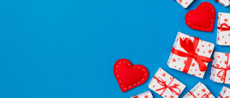 Top view of festive gift boxes and red textile hearts on colorful background with copy space. St Valentine's day concept.の写真素材