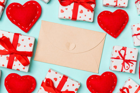 Top view of colorful valentine background made of craft envelope, gift boxes and red textile hearts....