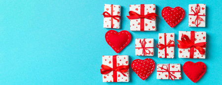Top view of white gift boxes and red textile hearts on colorful background. Valentine's Day concept.