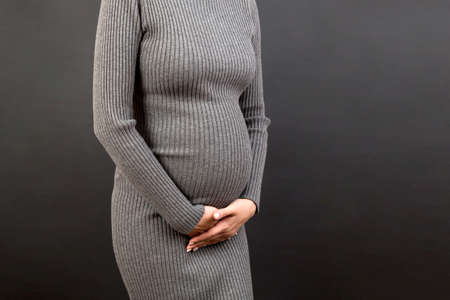 urinary incontinence during pregnancy. Abdominal pain during pregnancy. Maternity healthcare concept on colored background.の写真素材