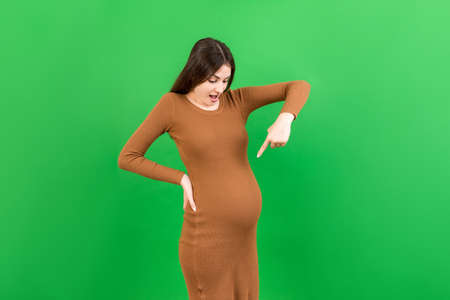 Young surprise or shocked woman pregnant isolated colored background. expression female.の写真素材