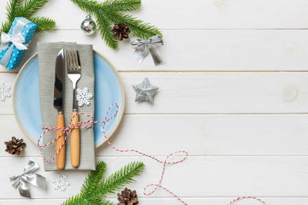 Christmas table place setting with christmas decor and plates, kine, fork and spoon. Christmas holiday background. Top view with copy space.の写真素材