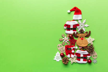 Christmas tree made from colored suit santa decoration on colored background, view from above. New Year minimal concept with copy space.の写真素材