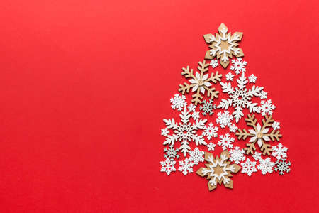 Christmas tree made from colored snowflakes decoration on colored background, view from above. New...