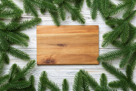 Festive table decoration with New Year branches and an empty plate. Top view with space for text....