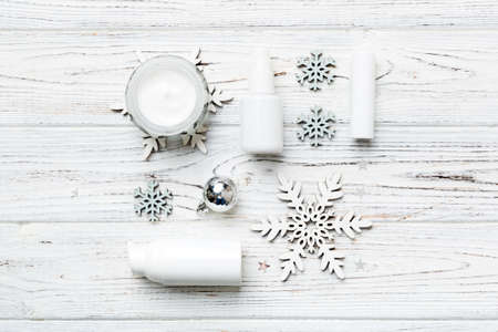 Makeup products and Christmas decorations on color background. Top view New year Beauty concept.の写真素材